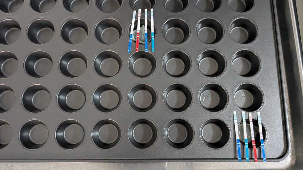 Test strips show results of drug testing. Paper wrapping tested positive for fentanyl and methamphetamine.