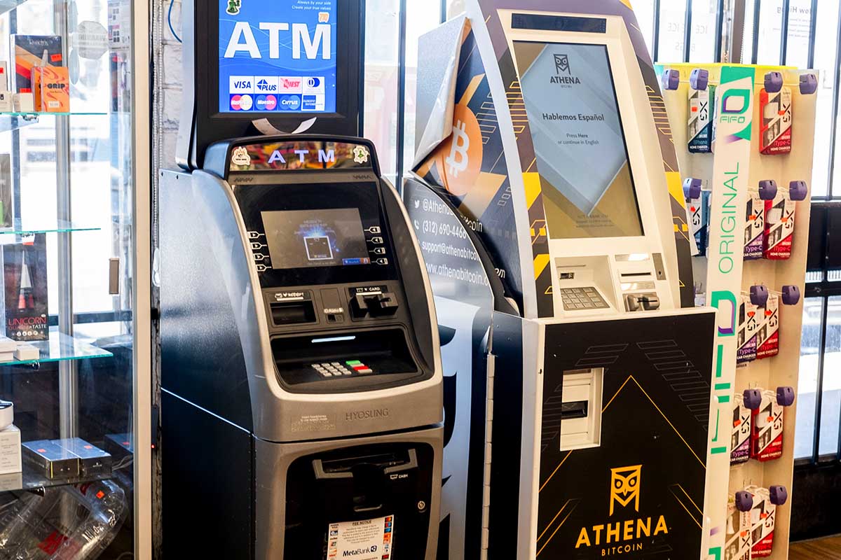Photo of an Athena bitcoin ATM beside a traditional cash ATM in a convenience store.
