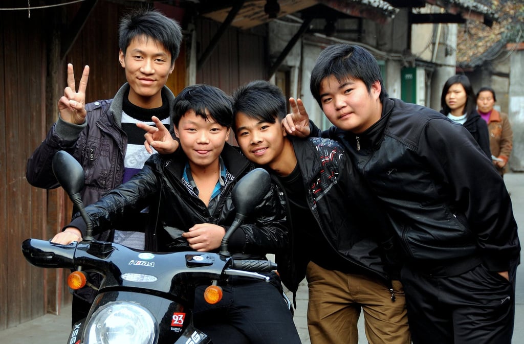 Four young high school students on their way home after class in China flash the peace sign for the camera. Photo: Shutterstock Four young high school students on their way home after class in China flash the peace sign for the camera. Photo: Shutterstock