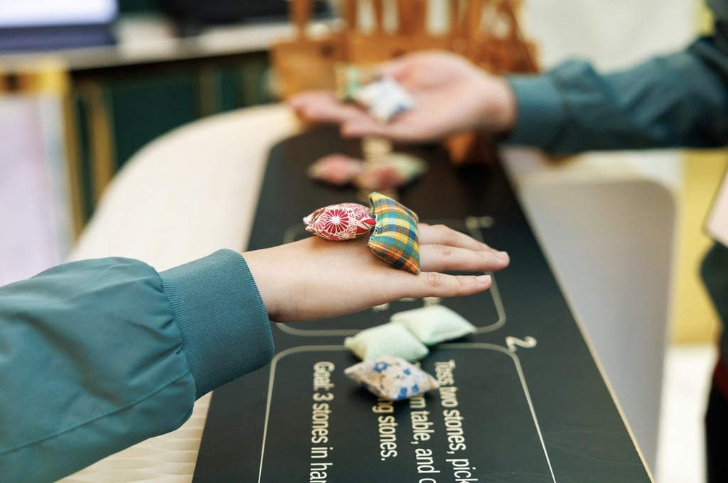 Players take part in a game of ‘five stones’ using pieces specially handcrafted for the summit by elderly artisans from Gingko House. Players take part in a game of ‘five stones’ using pieces specially handcrafted for the summit by elderly artisans from Gingko House.