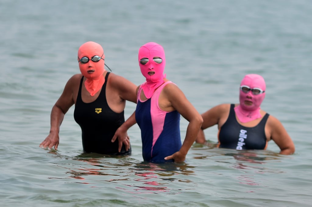Three women wearing so-called facekinis to cool off while they bathe in the sea in China. Photo: Getty Images Three women wearing so-called facekinis to cool off while they bathe in the sea in China. Photo: Getty Images