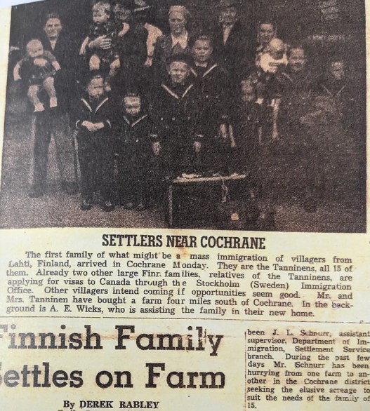 A historical newspaper clipping includes a black-and-white photo titled "Settlers Near Cochrane," which shows a large family (the Tanninens, a family of 15 from Lahti, Finland) who immigrated to Canada. Below, the headline of the story says “Finnish Family Settles on Farm.”