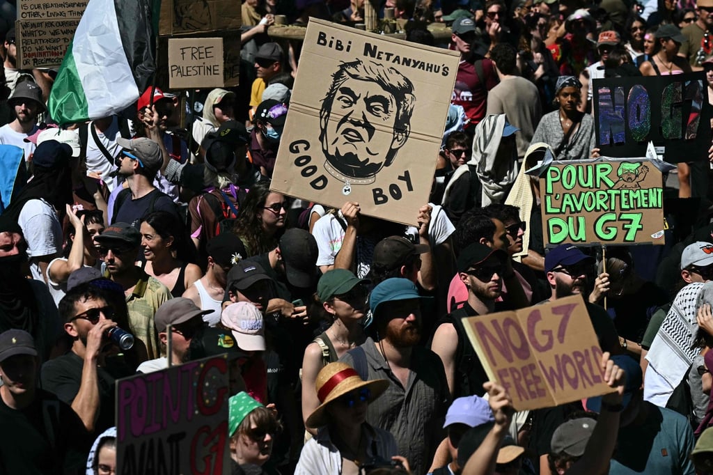 Demonstrators with placards, including one (centre) depicting US President Donald Trump and reading ‘Bibi Netanyahu’s good boy’ during an anti-G& rally ahead of the group’s summit in Geneva, on Sunday. Photo: AFP Demonstrators with placards, including one (centre) depicting US President Donald Trump and reading ‘Bibi Netanyahu’s good boy’ during an anti-G& rally ahead of the group’s summit in Geneva, on Sunday. Photo: AFP