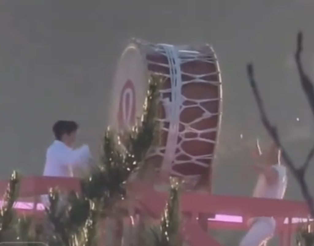Two men, above, beat the drum as it sits atop the Great Wall. Photo: Douyin