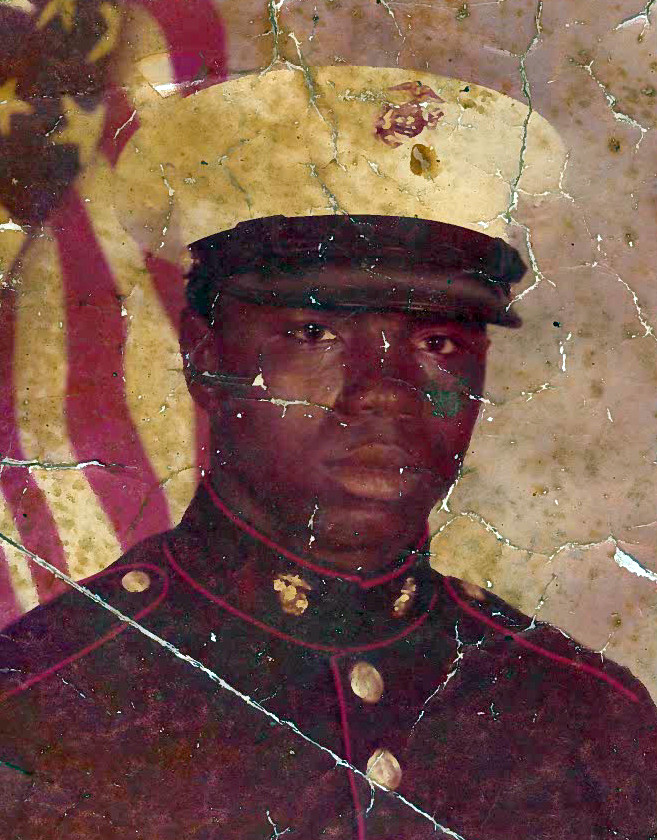 A young man in a Marines uniform poses for a portrait.