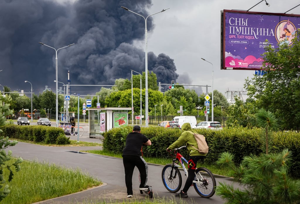 Muscovites watch smoke billowing in the background following a Ukrainian drone attack on Thursday. Photo: EPA Muscovites watch smoke billowing in the background following a Ukrainian drone attack on Thursday. Photo: EPA