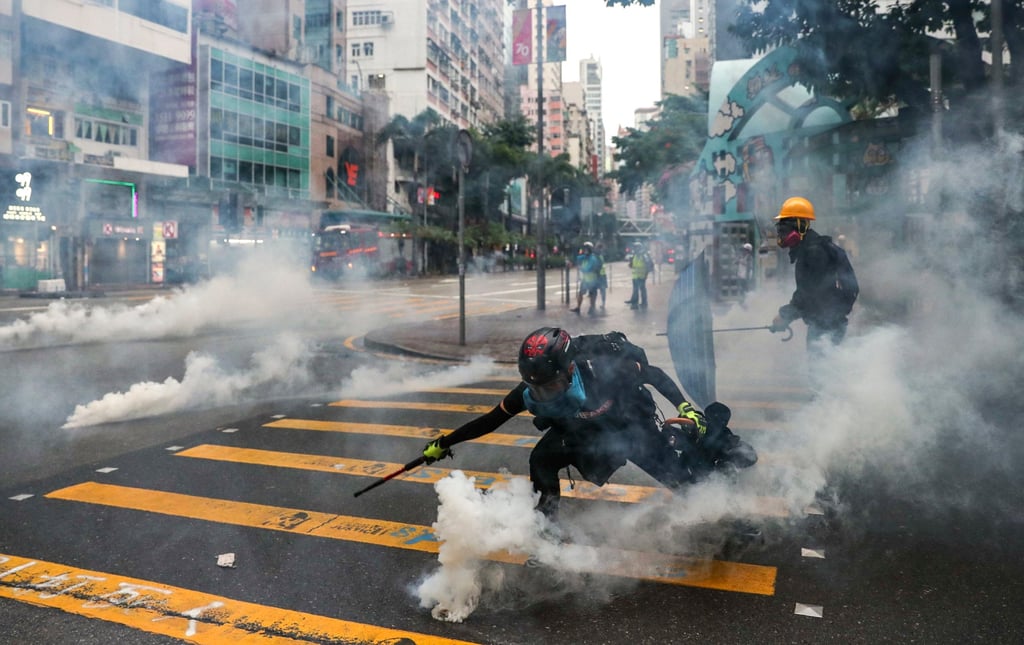 Anti-government protesters react to tear gas in Wan Chai following a rally in defiance of the anti-mask law issued by the government on October 5, 2019. Photo: Sam Tsang Anti-government protesters react to tear gas in Wan Chai following a rally in defiance of the anti-mask law issued by the government on October 5, 2019. Photo: Sam Tsang