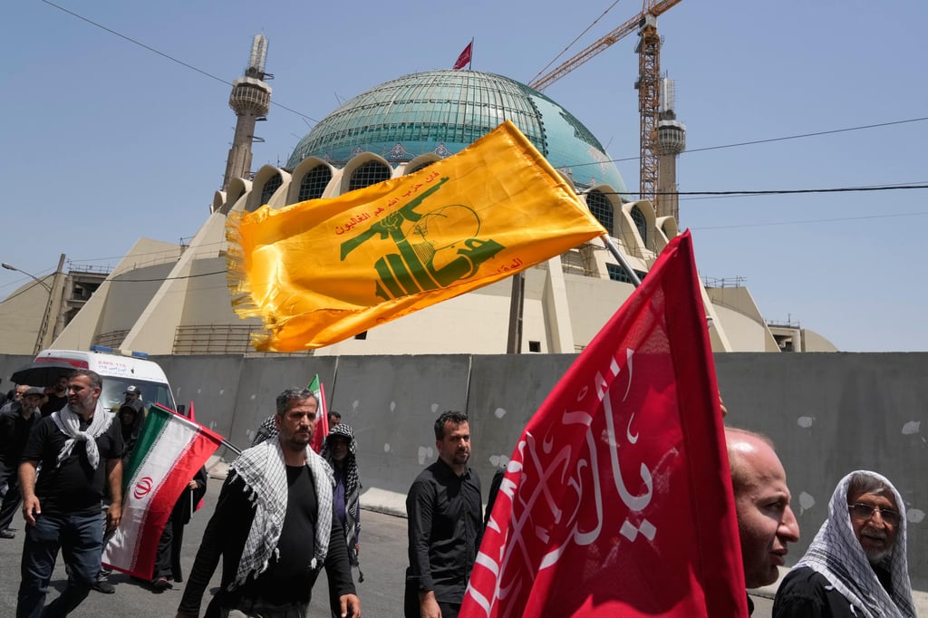 Mourners walk outside the Imam Khomeini Mosalla Grand Mosque as one carries a Hezbollah flag during the days-long funeral ceremonies for the late Iranian Supreme Leader Ayatollah Ali Khamenei and members of his family in Tehran, Iran, on Saturday. Photo: AP Mourners walk outside the Imam Khomeini Mosalla Grand Mosque as one carries a Hezbollah flag during the days-long funeral ceremonies for the late Iranian Supreme Leader Ayatollah Ali Khamenei and members of his family in Tehran, Iran, on Saturday. Photo: AP