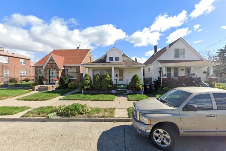 A row of houses and a parked truck, seen from the street.