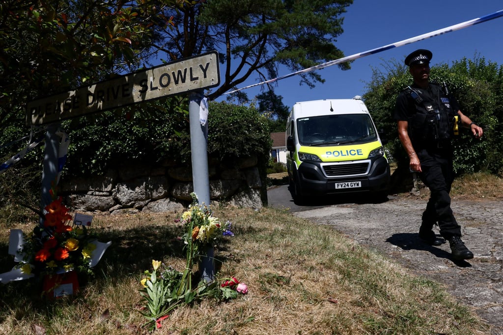 A police officer walks past flower tributes left outside the home of Ann Widdecombe in Haytor, Britain, on Saturday. Photo: Reuters A police officer walks past flower tributes left outside the home of Ann Widdecombe in Haytor, Britain, on Saturday. Photo: Reuters