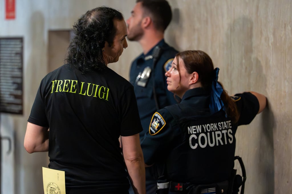 A man in a “Free Luigi” shirt speaks to a court officer during a pre-trial hearing in New York on Tuesday. Photo: EPA A man in a “Free Luigi” shirt speaks to a court officer during a pre-trial hearing in New York on Tuesday. Photo: EPA