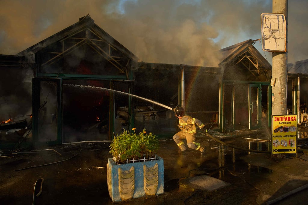 Firefighters try to put out a fire at a city book market following a Russian missile attack in Kyiv on Sunday. Photo: AP Firefighters try to put out a fire at a city book market following a Russian missile attack in Kyiv on Sunday. Photo: AP