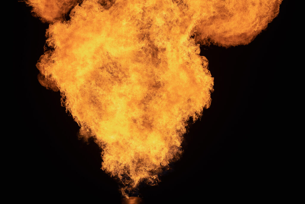 A large flare burns natural gas at night.
