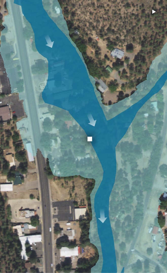 A satellite image shows a road and surrounding buildings in Ruidoso, New Mexico. The road is labeled Sudderth Drive. The Riverview RV Park is labeled on the north side of the road. A dark blue overlay indicates the location of the floodway. A lighter blue overlay indicates the location of the floodplain. The Trotter family camp site is located within the bounds of the floodplain and at the edge of the floodway.